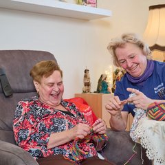 Senioren und Pflegerin am Stricken 
