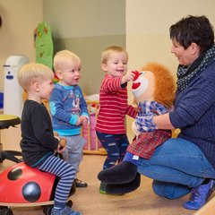 Kinder spielen in der Kindertagesstätte Sonneneck mit einer puppe 