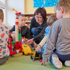 Kinder in der Spielecke mit Erzieherin